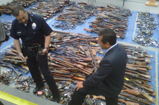 Los Angeles Police Chief Charlie Beck and Mayor Antonio Villaraigosa stand over the more than 2,500 guns recovered through the city's gun buyback program.