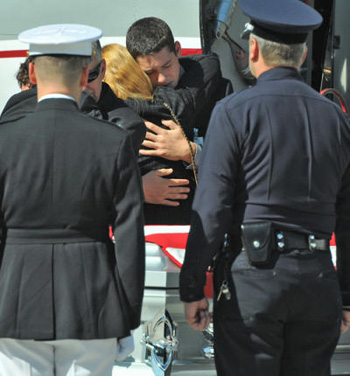 The body of LAPD officer and Marine Staff Sargeant Joshua Cullins, 28, of Simi Valley, arrived at LAX Thursday from Afghanistan where he was killed by an IED. Brother Donovan Cullins hugs his mother Barbara, while his father Jim hugs younger brother Cooper.