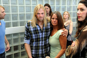 Adam Colvey, center, the fiance of murder victim Cheree Osmanhodzic, gets a hug from Pam Kuse following the news conference about the arrest of Omar Armando Loera, Wednesday, Oct. 13, 2010, at the LAPD North Hollywood station.