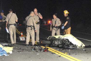 California Highway Patrol officers and Orange County Fire Authority firefighters survey scene of a double fatal motorcycle head-on collision on Santiago Canyon Road near Irvine Lake, Sunday.