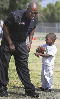 Tommie "T-Top" Rivers coaches the South Valley Raiders youth football team, mostly 8-year-olds, at Whitsett Park in North Hollywood.