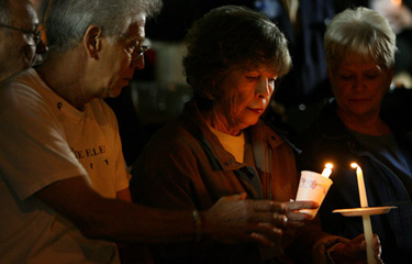 Joseph Bonaminio and his wife, Geraldine, light a candle in memory of their son, Riverside police officer Ryan Bonaminio, during a candlelight vigil Thursday in Riverside.