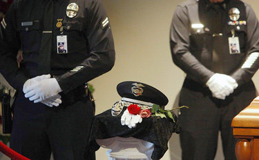 Two Los Angeles police officers stand guard beside the casket, patrol hat, gloves and badge of former Chief Daryl F. Gates at a remembrance ceremony at police headquarters downtown.