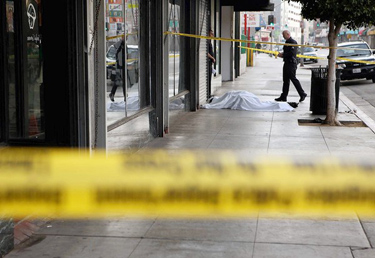 LAPD officers Brent Phillips, right, and Jose Zambada investigate the shooting death of Conrad Phillip on Los Angeles Street near 6th Street last April. A suspect was charged in the homicide.