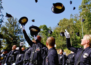 Newly graduated LAPD officers toss their hats into the air. Mayor Antonio Villaraigosa has repeatedly insisted that the department hire enough officers to replace those who resign or retire, keeping the force at 9,963.