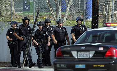 Officers search outside El Camino Real High School in Woodland Hills after a Los Angeles school police officer reported he had been shot Jan. 19. It later was determined that he had concocted the story.