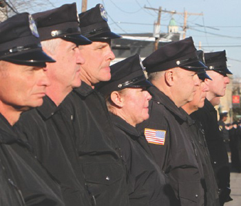 Woburn police officers stand outside the McLaughlin-Dello Russo Funeral Home in Woburn during the wake yesterday for slain Officer John "Jack" Maguire.