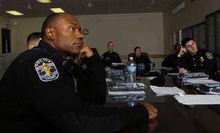 Louisville Metro Police officer Chad Johnson, left, watches the new PSAs from the Police Foundation with the rest of the 2nd division. The campaign is based around the phrase Could You Do It? (By Scott Utterback, The Courier-Journal) Dec. 29, 2010