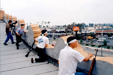 Armed men on a rooftop overlook Western Avenue during the 1992 Los Angeles riots. Many Koreans say the riots made them realize they needed more of a political presence.