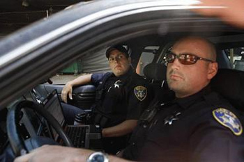 With news that 80 Oakland Police Officers will be laid off in a matter of hours, Oakland Police Officers Dometrius Fowler (l to r) and Paul Phillips report for third shift duty on Monday July 12, 2010 in Oakland, Calif. Both officers, who have been with the force in Oakland for 2 1/2 years, worry if these layoffs happen that they might be next to go. Fowler worries that crime will increase and says it is the mismanagement of money that is the real blame for this problem.