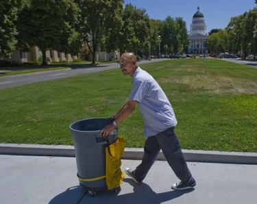 Dino Gomez, an employee of the state Department of General Services, collects trash around state buildings Wednesday after the governor ordered three furlough days a month, effective Sunday, for him and other state workers until a budget is passed. "He should have stuck to acting," Gomez said.