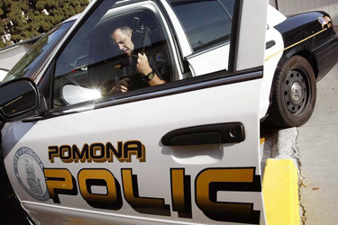 Sgt. Steve Congalton checks his weapon. Rank-and-file officers believe the department deserves credit for turning the tide on gang violence.