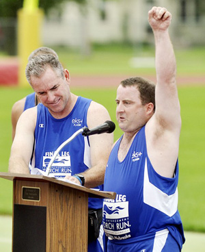 Special Olympian Robbie Strickland pumps his fist in the air while speaking during the Final Leg Law Enforcement Torch Run ceremony Monday at Memorial Field. Gary Beecher, left, also spoke at the event.